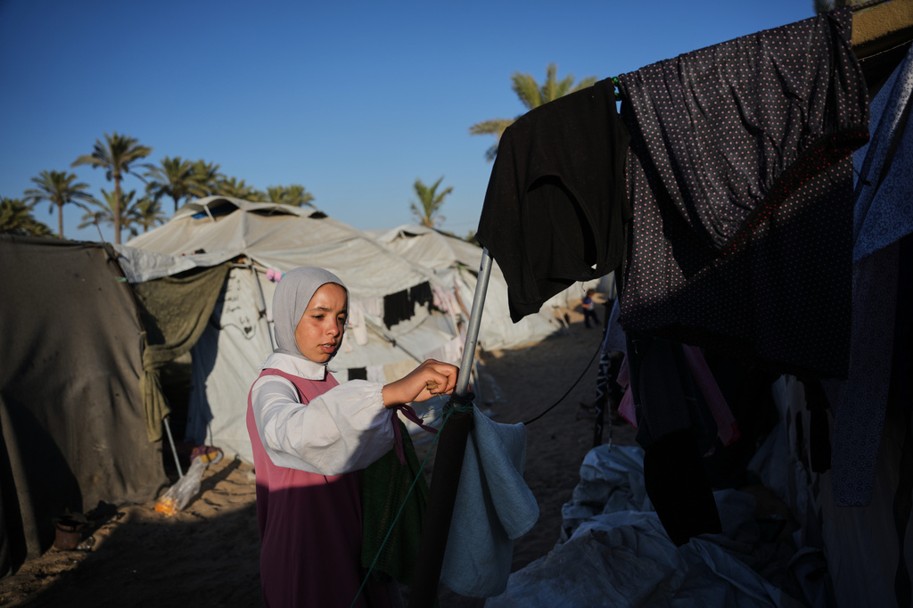 Palestinian orphan Dina Zourob, 17, hangs laundry outside her tent at an orphanage camp in Khan Younis, southern Gaza Strip, Sunday, June 7, 2026. (AP Photo/Abdel Kareem Hana)