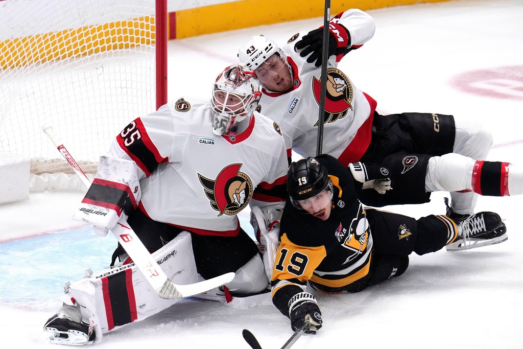 Ottawa Senators' Tyler Kleven (43) and Pittsburgh Penguins' Connor Dewar (19) collide with Senators goaltender Linus Ullmark (35) during the first period of an NHL hockey game in Pittsburgh, Monday, Feb. 2, 2026. (AP Photo/Gene J. Puskar)