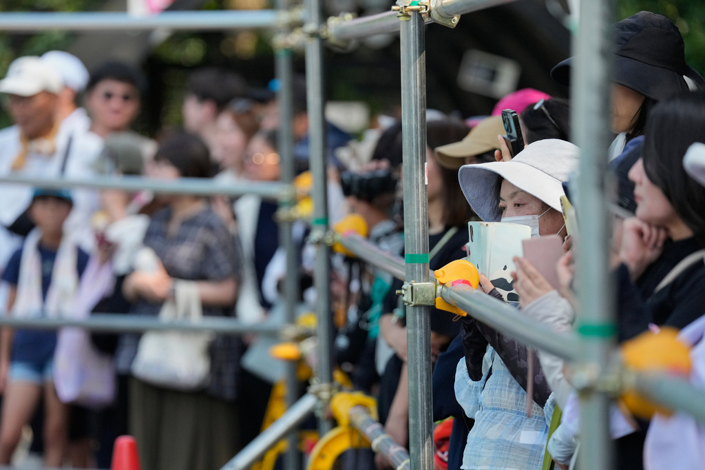 Visitors gather to watch Punch, a young Japanese macaque, at the Ichikawa City Zoological and Botanical Garden in Ichikawa, east of Tokyo, Thursday, July 23, 2026. (AP Photo/Eugene Hoshiko)
