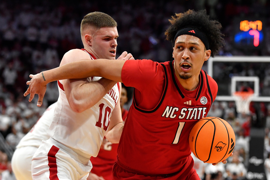 North Carolina State forward Darrion Williams (1) drives around Louisville guard Isaac McKneely (10) during the first half of an NCAA college basketball game in Louisville, Ky., Monday, Feb. 9, 2026. (AP Photo/Timothy D. Easley)