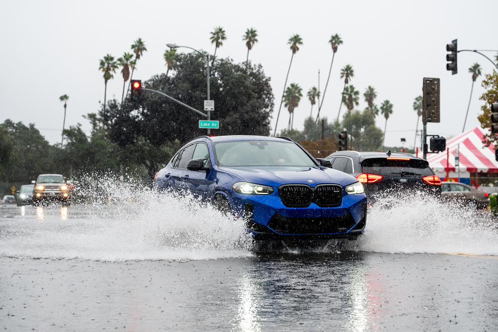 A vehicle crosses a flooded roadway in Pasadena, Calif., on Saturday, Nov. 15, 2025. (AP Photo/Noah Berger)