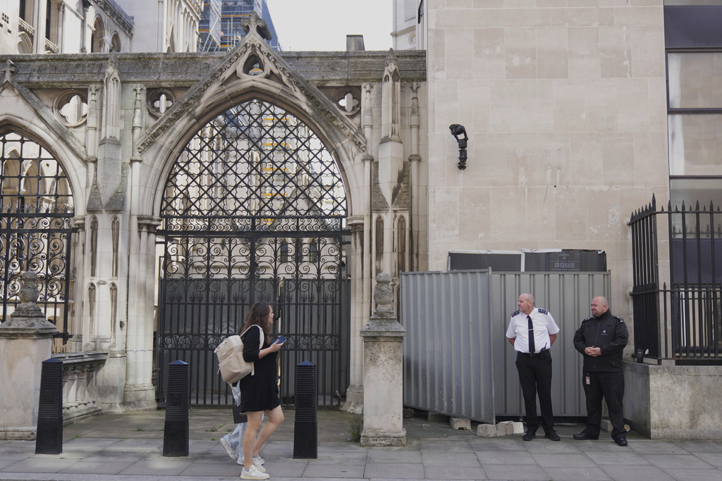 Banksy's latest artwork appears outside at the Royal Courts of Justice in London, which shows a judge using his gavel to strike a protester who is lying on the ground holding a placard has been covered up, Monday, Sept. 8, 2025. (AP Photo/Joanna Chan)