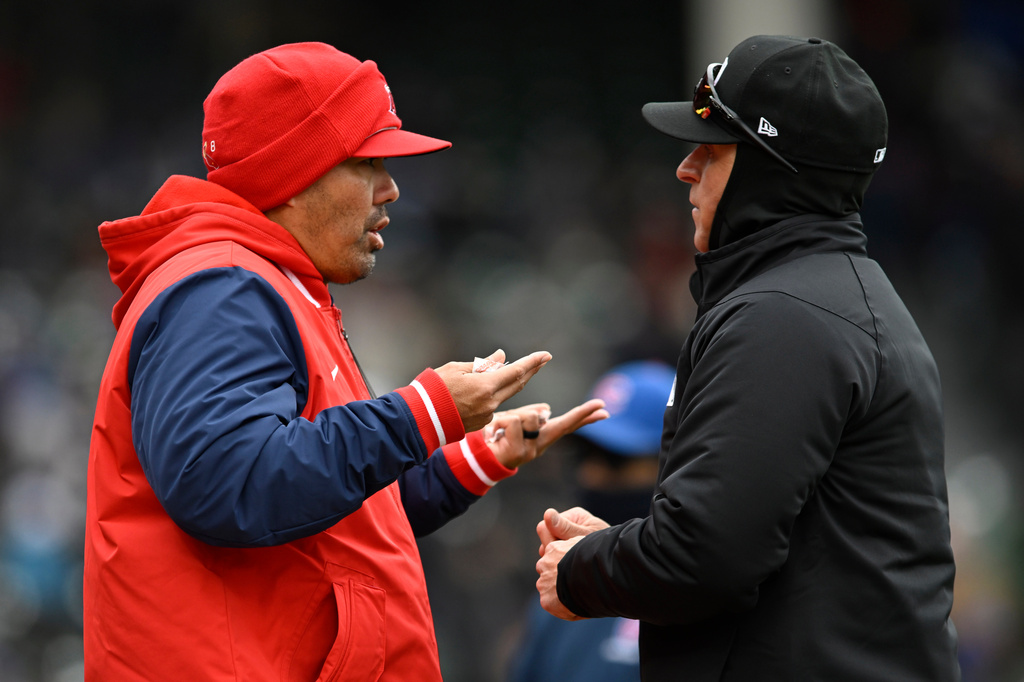 Los Angeles Angels manager Kurt Suzuki, left, attempts to challenge a play with an umpire during the third inning of a baseball game against the Chicago Cubs in Chicago, Wednesday, April 1, 2026. (AP Photo/Paul Beaty)