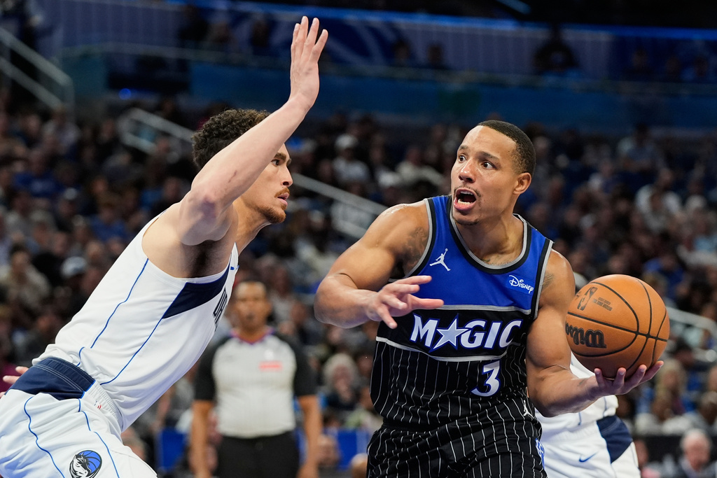 Orlando Magic guard Desmond Bane (3) drives to the basket against Dallas Mavericks forward Dwight Powell, left, during the second half of an NBA basketball game, Thursday, March 5, 2026, in Orlando, Fla. (AP Photo/John Raoux)