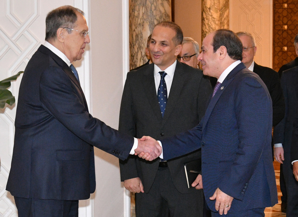 In this photo, provided by Egypt's presidency media office, Egyptian President Abdel-Fattah el-Sissi, front right, greets Russian Foreign Minister Sergey Lavrov, left, before their meeting at the Presidential Palace in Cairo, Egypt, Saturday, Dec. 20, 2025. (Egyptian Presidency Media Office via AP)