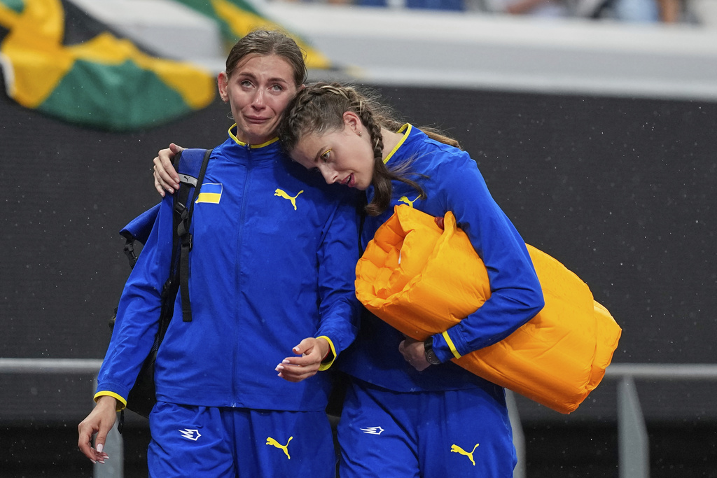 Ukraine's Yaroslava Mahuchikh, right, consoles Ukraine's Kateryna Tabashnyk after the women's high jump qualification at the World Athletics Championships in Tokyo, Thursday, Sept. 18, 2025. (AP Photo/Petr David Josek)