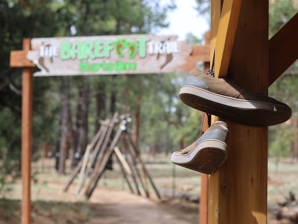 Shoes hang near the entrance of a barefoot trail near Flagstaff, Ariz, on Thursday, April 16, 2026. (AP Photo/Cheyanne Mumphrey)