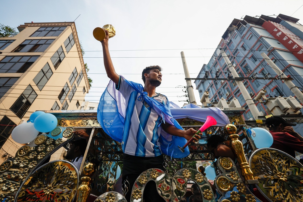 A Bangladeshi soccer fan wearing an Argentina jersey and holding a replica of the FIFA World Cup trophy in support of the team competing at the 2026 FIFA World Cup during a rally in Dhaka, Bangladesh, Tuesday, June 16, 2026. (AP Photo/Rajib Dhar)