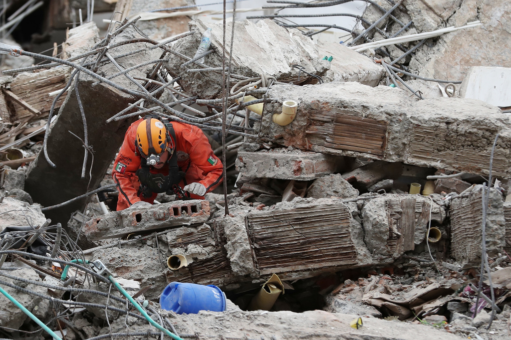 A Mexican rescue worker searches through the rubble two days after an earthquake struck Cali, Colombia, Wednesday, Aug. 12, 2026. (AP Photo/Santiago Saldarriaga)