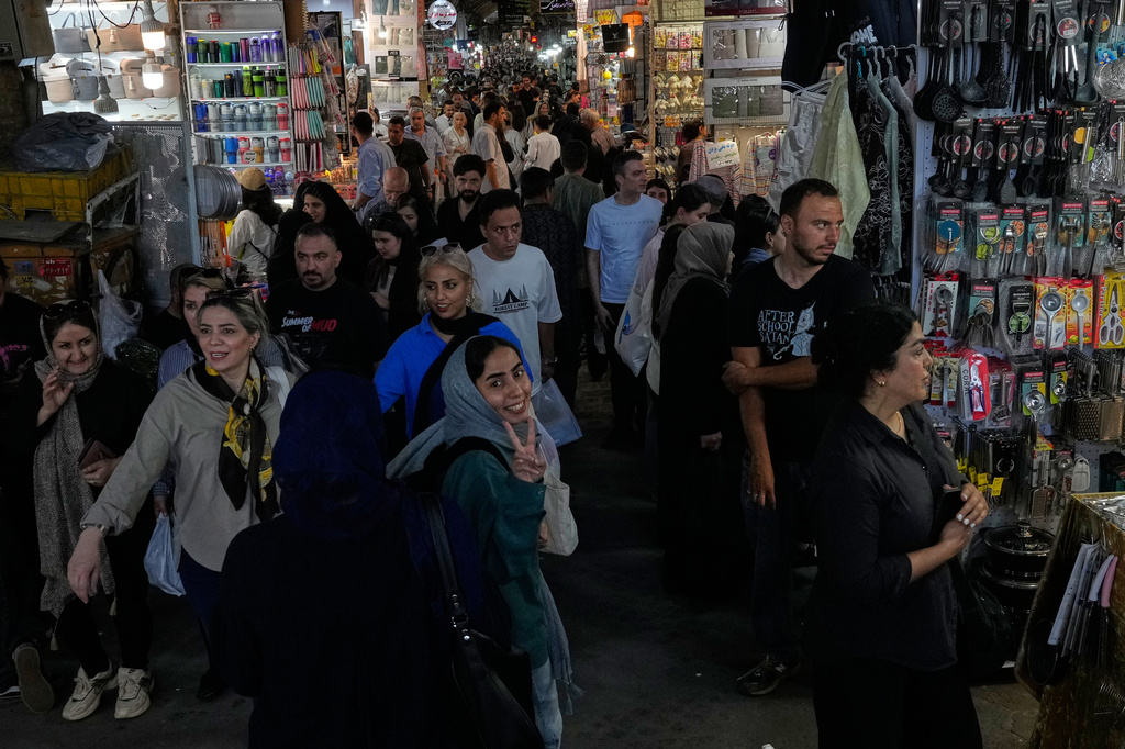 A woman flashes a victory sign while walking at Tehran's traditional main bazaar, Iran, Thursday, July 16, 2026. (AP Photo/Vahid Salemi)