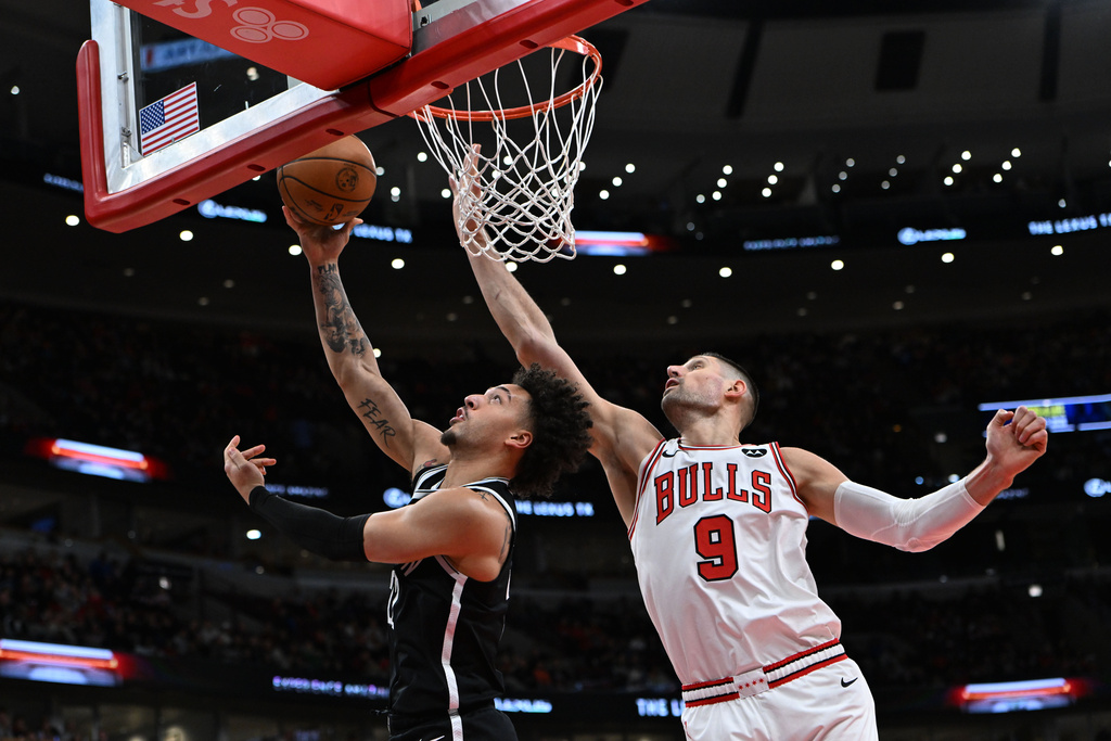 Brooklyn Nets' Jalen Wilson (22) goes up for a shot against Chicago Bulls' Nikola Vucevic (9) during the first half of an NBA basketball game Sunday, Jan. 18, 2026, in Chicago. (AP Photo/Paul Beaty)
