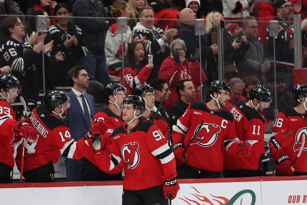New Jersey Devils center Dawson Mercer (91) high-fives teammates after a goal in the first period of an NHL hockey game against the Carolina Hurricanes, Sunday, Jan. 4, 2026, in Newark, N.J. (AP Photo/Heather Khalifa)