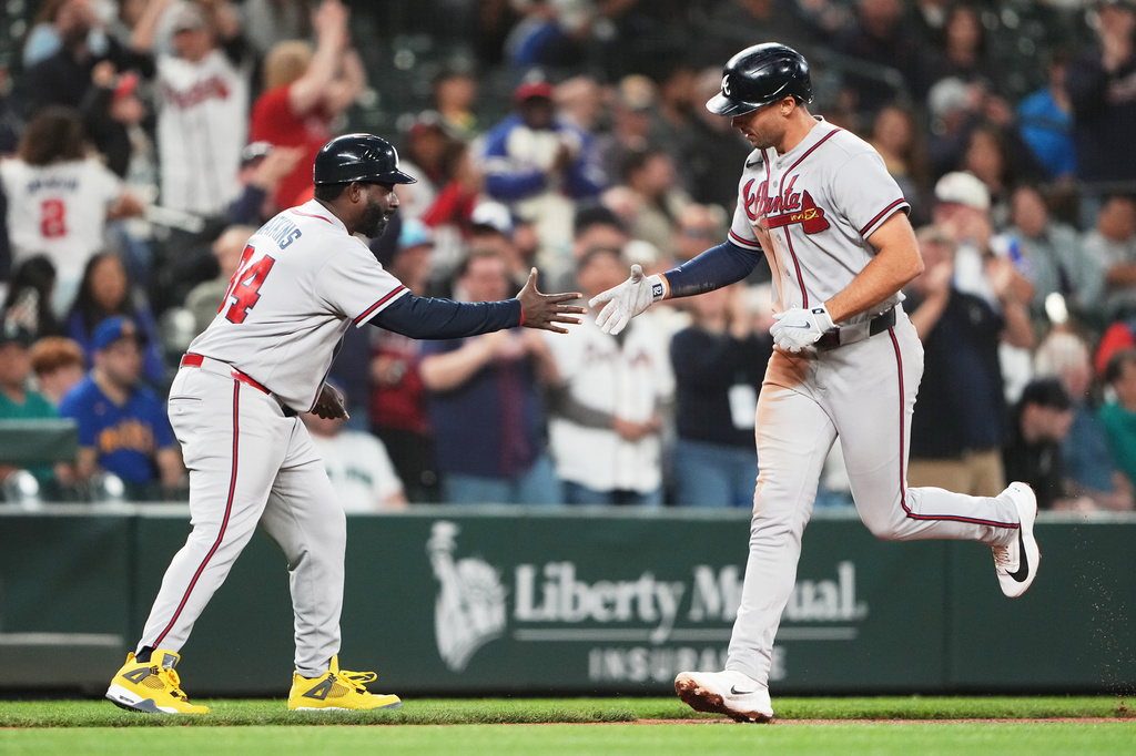 Atlanta Braves' Matt Olson greets third base coach Tommy Watkins while jogging home after hitting a solo home run against the Seattle Mariners during the ninth inning of a baseball game, Tuesday, May 5, 2026, in Seattle. (AP Photo/Lindsey Wasson)