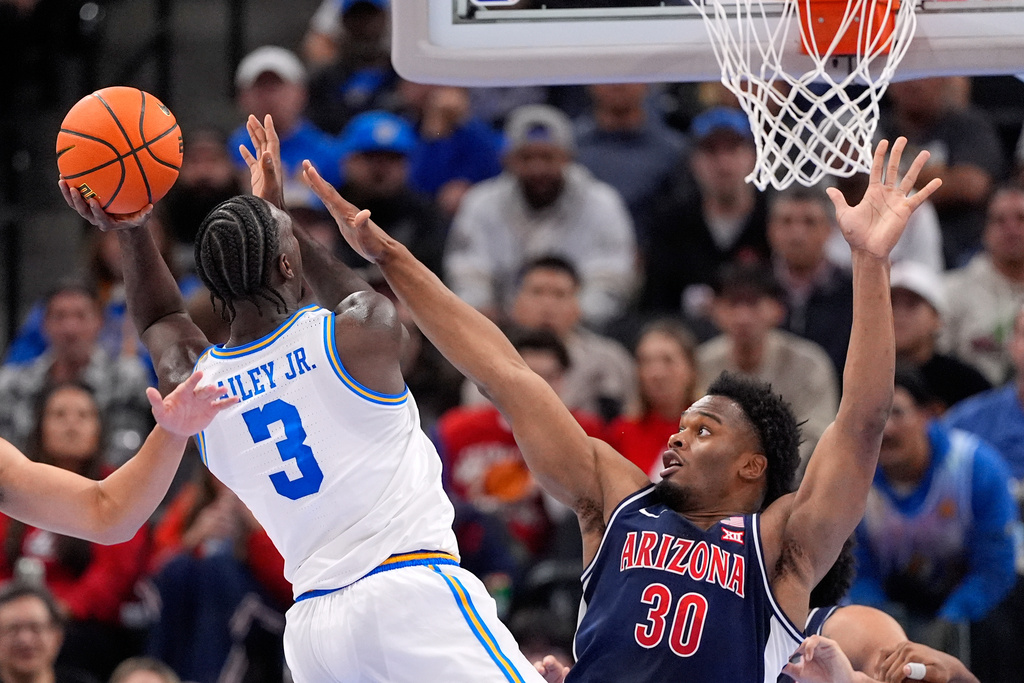 UCLA guard Eric Dailey Jr., left, shoots as Arizona's Tobe Awaka defends during the first half of a Hall of Fame Series college basketball game Friday, Nov. 14, 2025, in Inglewood, Calif. (AP Photo/Mark J. Terrill)