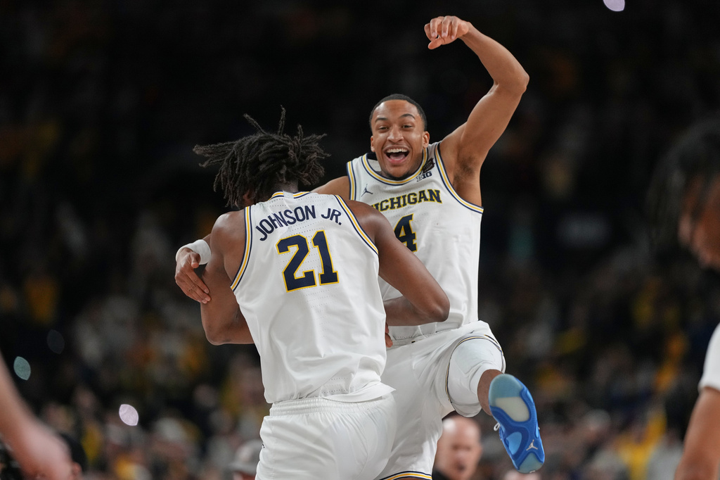 Michigan's Nimari Burnett (4) and Morez Johnson Jr. celebrate after defeating UConn in the NCAA college basketball tournament national championship game at the Final Four, Monday, April 6, 2026, in Indianapolis. (AP Photo/Michael Conroy)