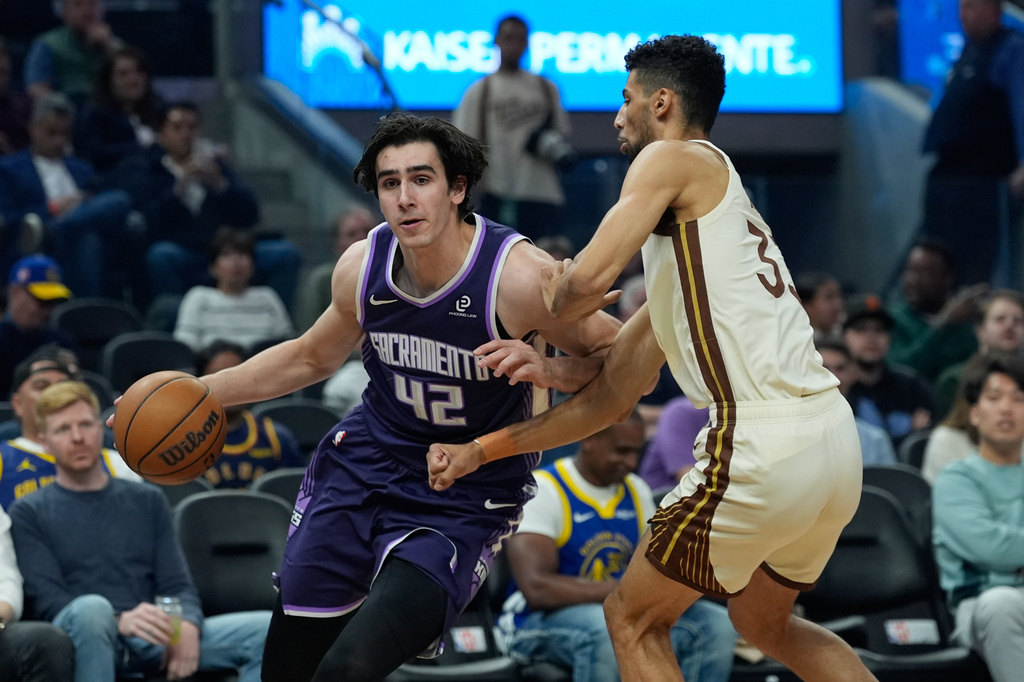 Sacramento Kings center Maxime Raynaud, left, moves the ball while defended by Golden State Warriors forward Malevy Leons during the first half of an NBA basketball game, Tuesday, April 7, 2026, in San Francisco. (AP Photo/Godofredo A. Vásquez)