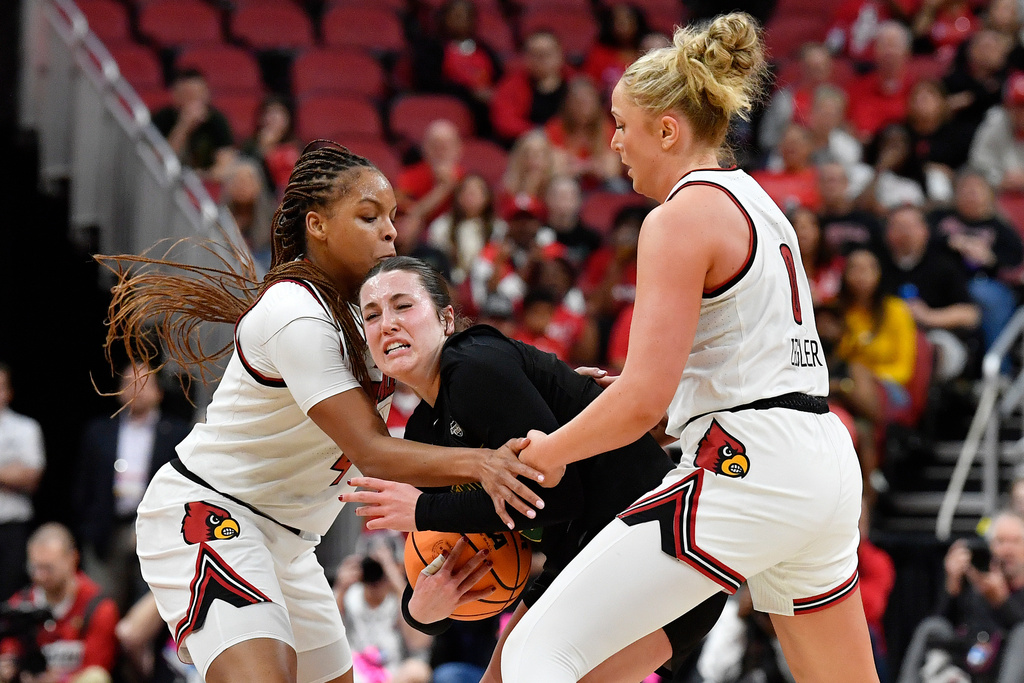 Vermont guard Emma Haan (3) battles for the ball with Louisville forward MacKenly Randolph, left, and Laura Ziegler (0) during the first half in the first round of the NCAA college basketball tournament, Saturday, March 21, 2026 in Louisville, Ky. (AP Photo/Timothy D. Easley)