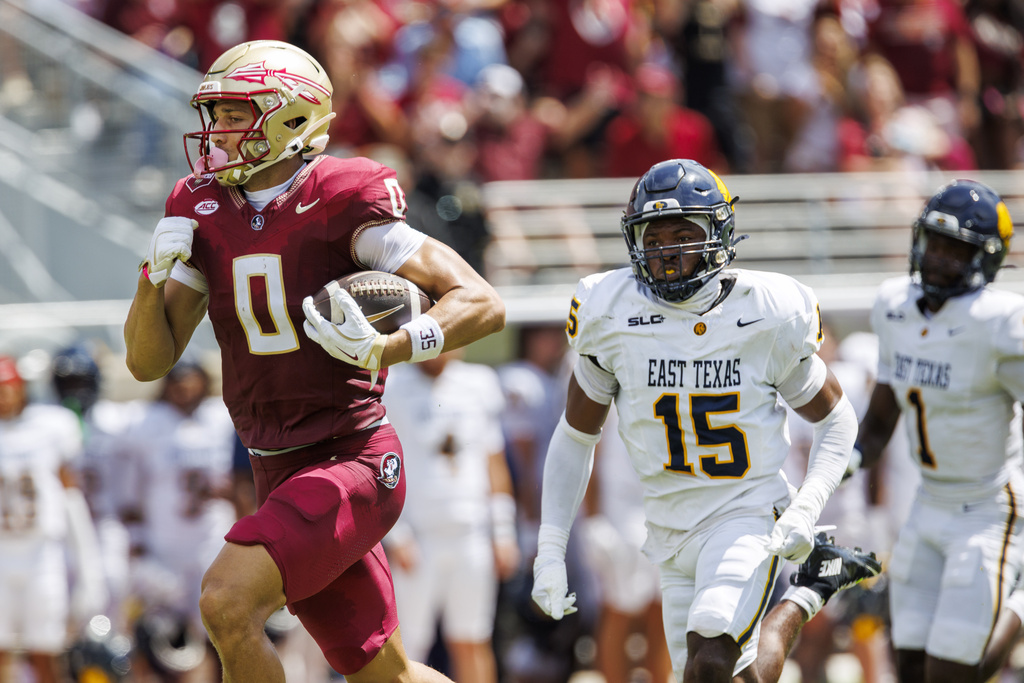 Florida State wide receiver Duce Robinson (0) races 82-yards for a touchdown as East Texas A&M defensive back Cinque Williams (15) and defensive back Kaleb Miles (1) pursue during the first half of an NCAA college football game, Saturday, Sept. 6, 2025, in Tallahassee, Fla. (AP Photo/Colin Hackley)