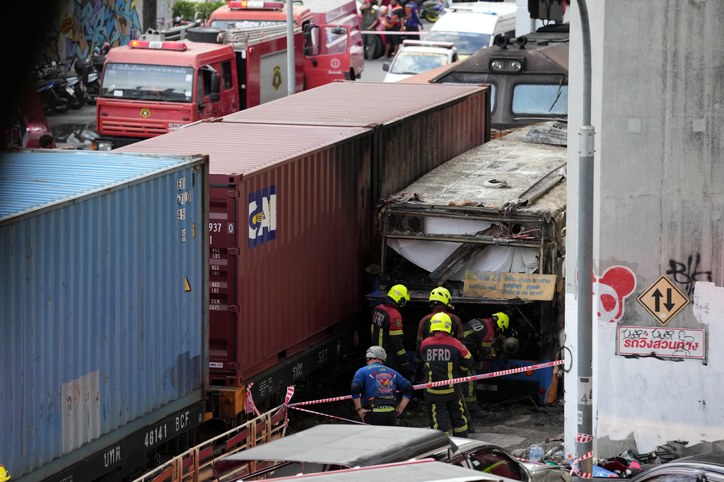 First responders work at a train crash site near an airport rail link station in Bangkok, Thailand, Saturday, May 16, 2026. (AP Photo/Sakchai Lalit)