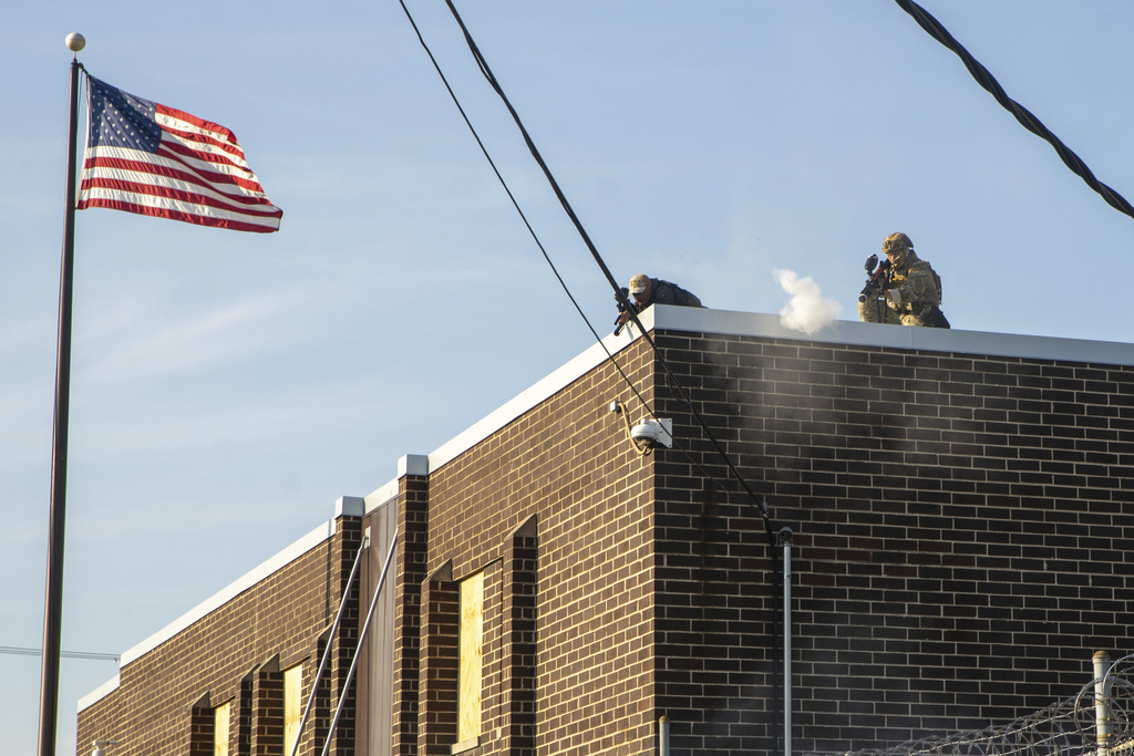 CBP and Immigration and Customs Enforcement special response team officers shoot nonlethal chemical projectiles at protesters from the roof of the Immigration and Customs Enforcement facility in Broadview, Ill., Friday, Sept. 19, 2025. . (Zubaer Khan/Chicago Sun-Times via AP)