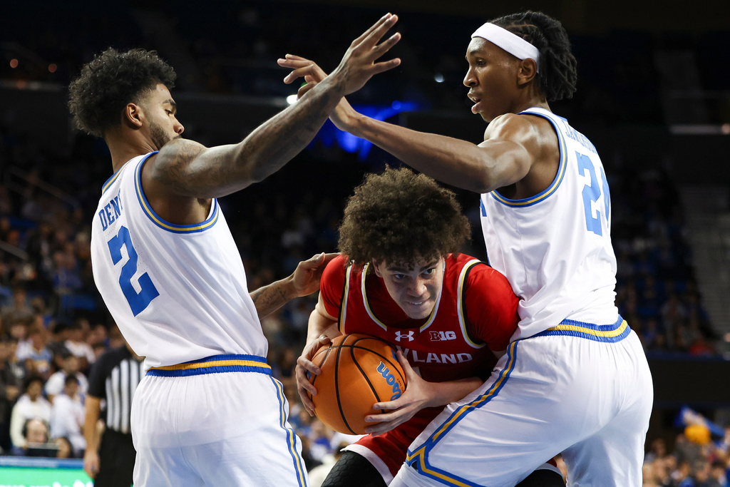 Maryland guard Darius Adams, center, drives against UCLA guard Donovan Dent (2) and center Steven Jamerson II, right, during the first half of an NCAA college basketball game, Saturday, Jan. 10, 2026, in Los Angeles. (AP Photo/Jessie Alcheh)