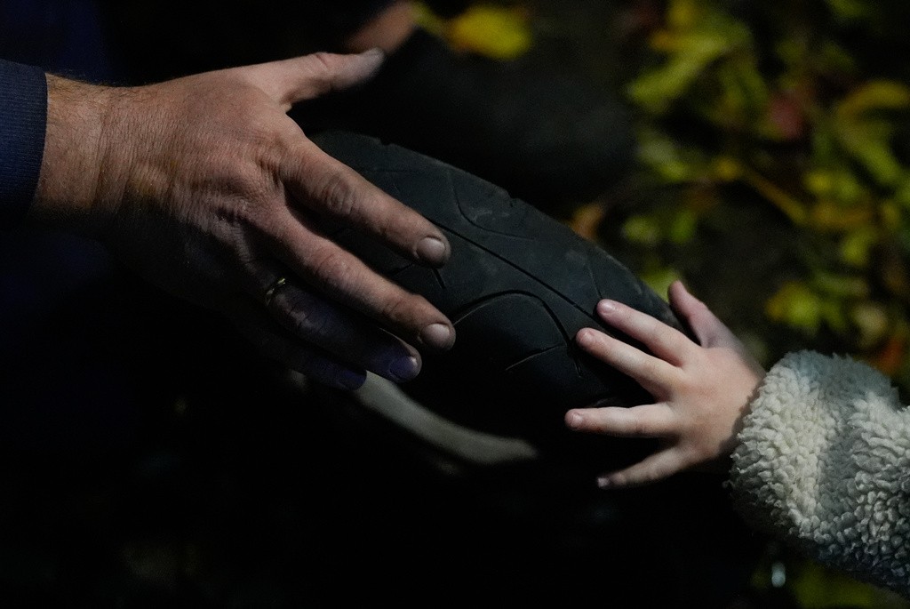 CORRECTS FAMILY NAME TO ADAMCHUK - Sashko Adamchuk, right, helps his dad work on a moped, the family's only method of transportation while they save up for a car, Friday, Oct. 24, 2025, in Kyiv region, Ukraine. (AP Photo/Julia Demaree Nikhinson)