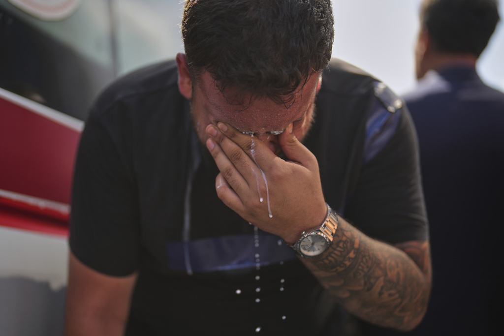 A supporter of Turkey's main opposition Republican People's Party (CHP) pours milk on his eyes to alleviate the effects of tear gas launched by Turkish police, at the party's headquarters in Istanbul, Turkey, Monday, Sept. 8, 2025. (AP Photo/Francisco Seco)