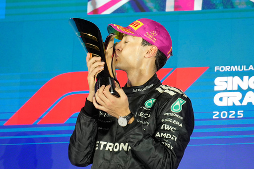 Mercedes driver George Russell of Britain kisses his trophy as he celebrates after winning the Singapore Formula One Grand Prix at the Marina Bay Street Circuit in Singapore, Sunday, Oct. 5, 2025. (AP Photo/Vincent Thian) Mercedes driver George Russell of Britain kisses his trophy as he celebrates after winning the Singapore Formula One Grand Prix at the Marina Bay Street Circuit in Singapore, Sunday, Oct. 5, 2025. (AP Photo/Vincent Thian)