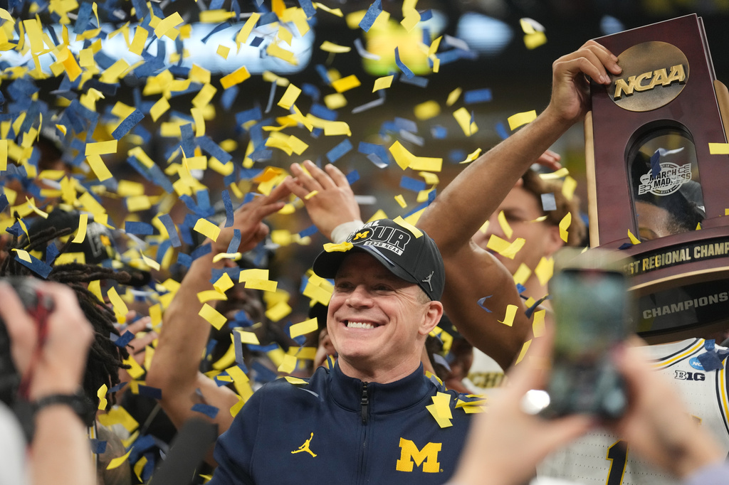 Michigan head coach Dusty May celebrates with his team after defeating Tennessee in the Elite Eight of the NCAA college basketball tournament, Sunday, March 29, 2026, in Chicago. (AP Photo/Erin Hooley)