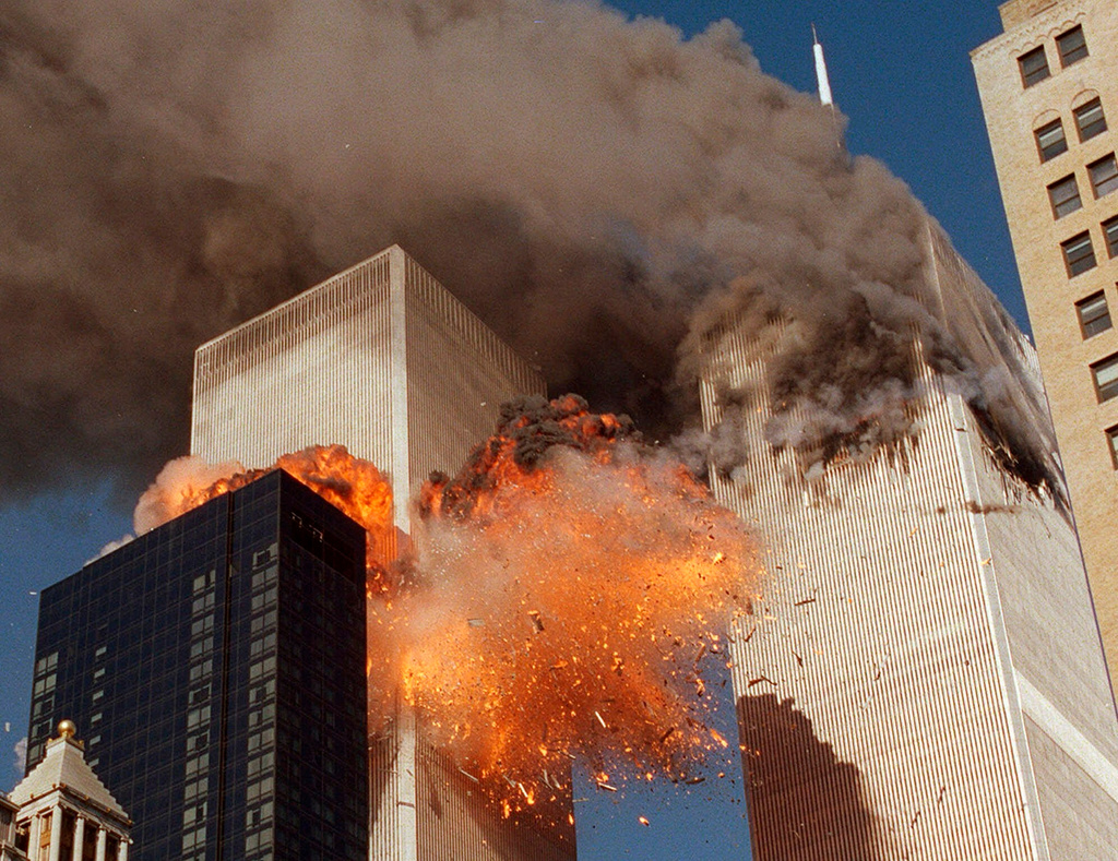 FILE - Smoke billows from one of the towers of the World Trade Center and flames and debris explode from the second tower in New York, Sept. 11, 2001. (AP Photo/Chao Soi Cheong, File)