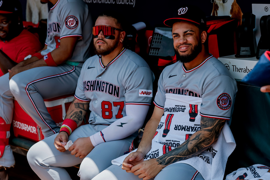 Washington Nationals' Luis García Jr., right, sits in the dugout with Andrés Chaparro (87) after he was scratched from the starting lineup before a baseball game against the Atlanta Braves, Sunday, Aug. 2, 2026, in Atlanta. (AP Photo/Erik S. Lesser)