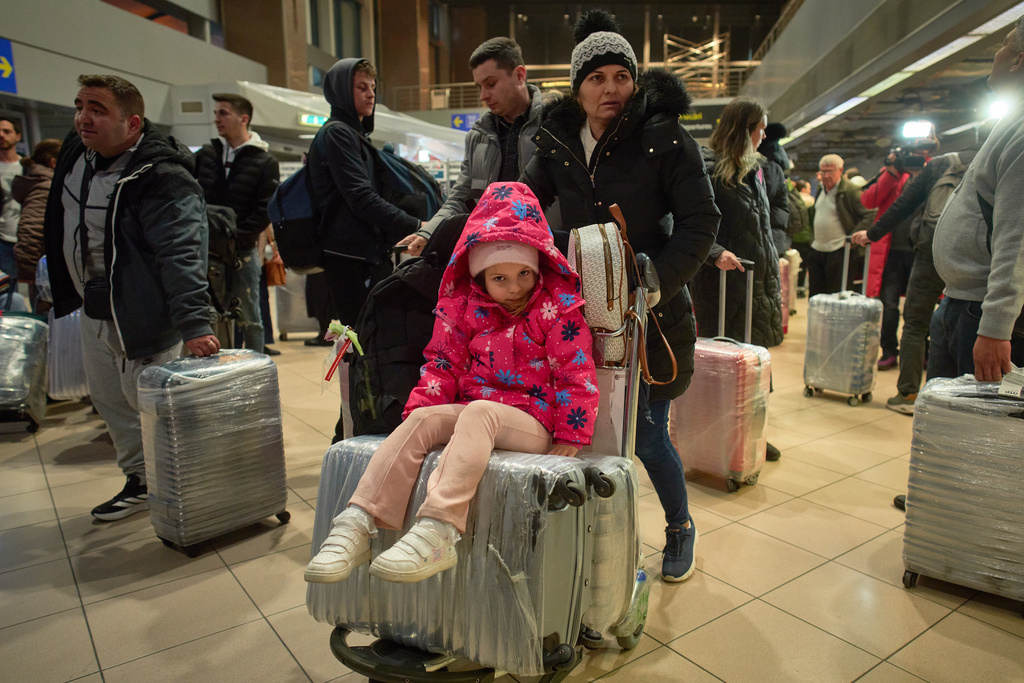 Antonia, 5 years old, sits on suitcases upon arriving at the Henri Coanda International airport after being evacuated from Israel via Egypt on a commercial flight in Otopeni, Romania, Tuesday, March 3, 2026. (AP Photo/Vadim Ghirda)