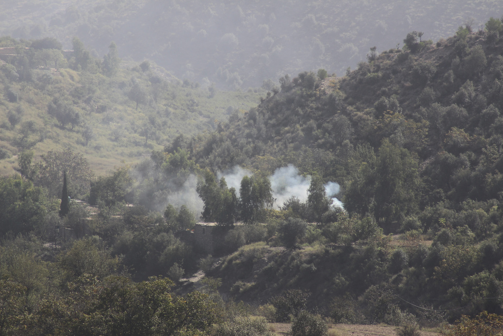 Smoke rises from a hillside following overnight clashes between Afghan and Pakistani forces along the border in the Zazai Maidan district of Khost province, Afghanistan, Sunday, Oct. 12, 2025. (AP Photo/Saifullah Zahir)