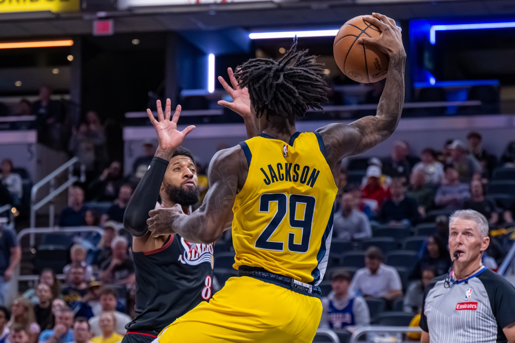 Philadelphia 76ers forward Paul George (8) braces as Indiana Pacers guard Quenton Jackson (29) prepares to ditch the ball on him to save it from going out-of-bounds during the second half of an NBA basketball game in Indianapolis, Friday, April 10, 2026. (AP Photo/Doug McSchooler)