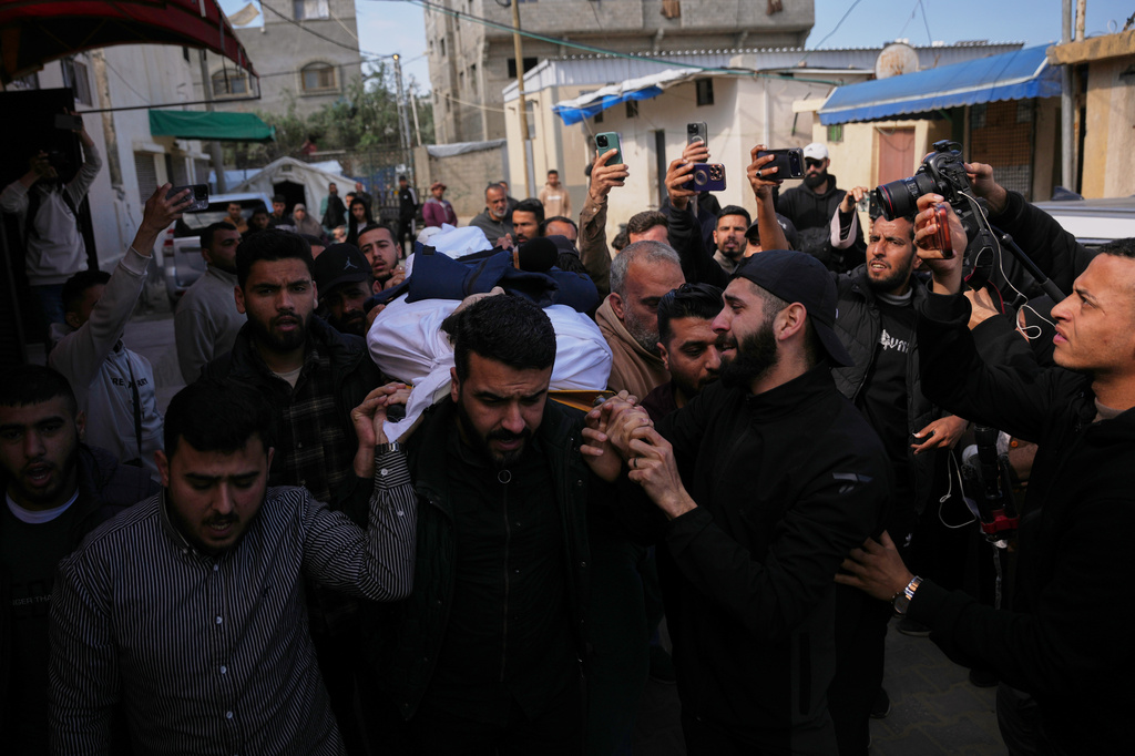 Mourners carry the body of Al Jazeera correspondent Mohammed Wishah, who was killed in an Israeli strike on his vehicle, during his funeral outside Al-Aqsa Hospital in Deir al-Balah, central Gaza Strip, Thursday, April 9, 2026. (AP Photo/Abdel Kareem Hana)