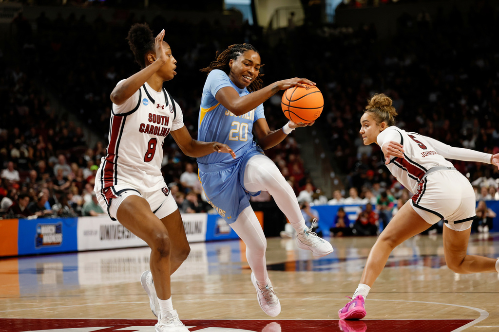 Southern guard Zaria Hurston (20) drives between South Carolina forward Joyce Edwards (8) and guard Tessa Johnson during the second half of the first round of the NCAA college basketball tournament, Saturday, March 21, 2026, in Columbia, S.C. (AP Photo/Nell Redmond)