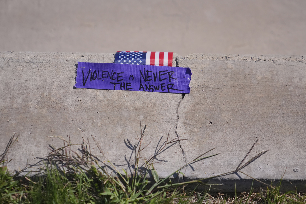 A note is left behind outside campus a day after the shooting of Charlie Kirk at Utah Valley University in Orem, Utah, Thursday, Sept. 11, 2025. (AP Photo/Lindsey Wasson)