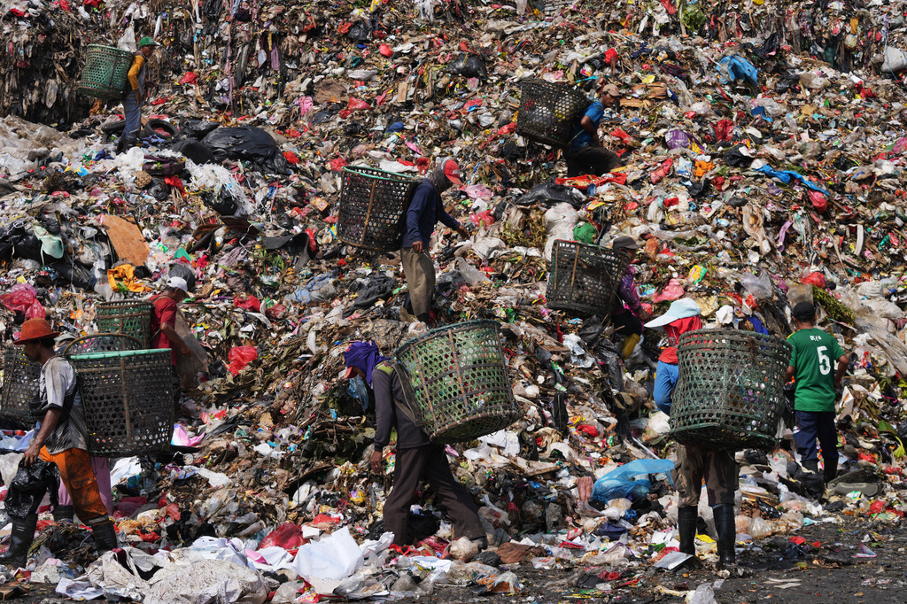 Waste pickers look for recyclable items in a pile of garbage at the Bantargebang landfill on the outskirts of Jakarta, Indonesia, Monday, July 6, 2026. (AP Photo/Tatan Syuflana)