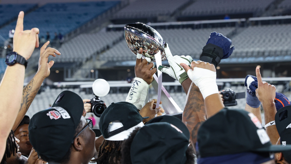 Virginia players hoist the trophy after defeating Missouri in the Gator Bowl NCAA college football game in Jacksonville, Fla., Saturday, Dec. 27, 2025. (AP Photo/Gary McCullough)