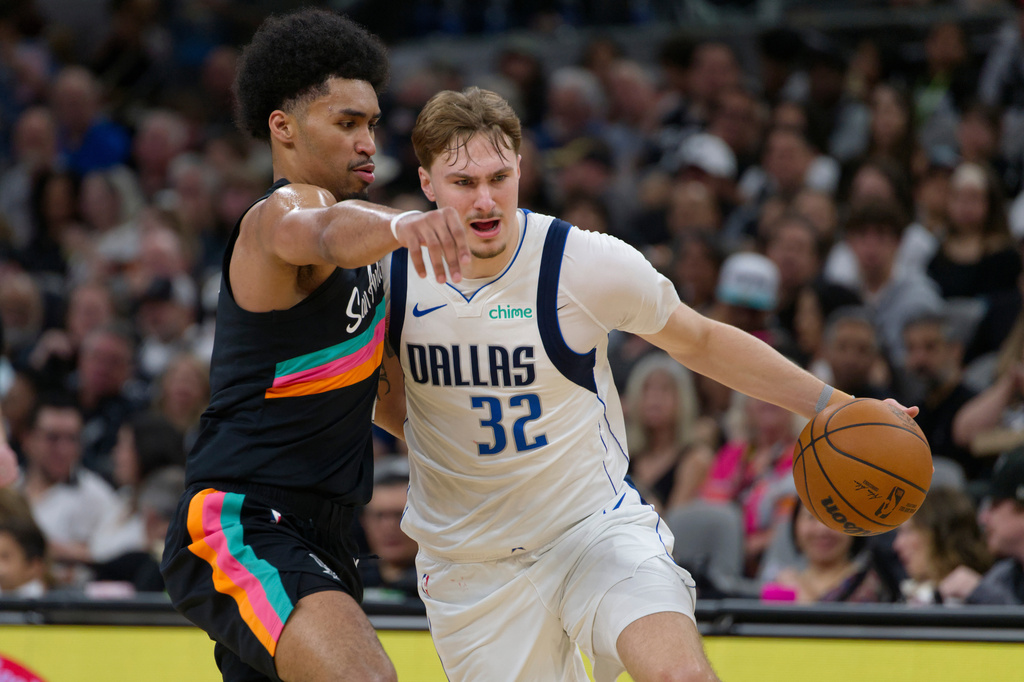 Dallas Mavericks guard Cooper Flagg (32) tangles with San Antonio Spurs guard Dylan Harper during the first half of an NBA basketball game, Friday, April 10, 2026, in San Antonio. (AP Photo/Darren Abate)