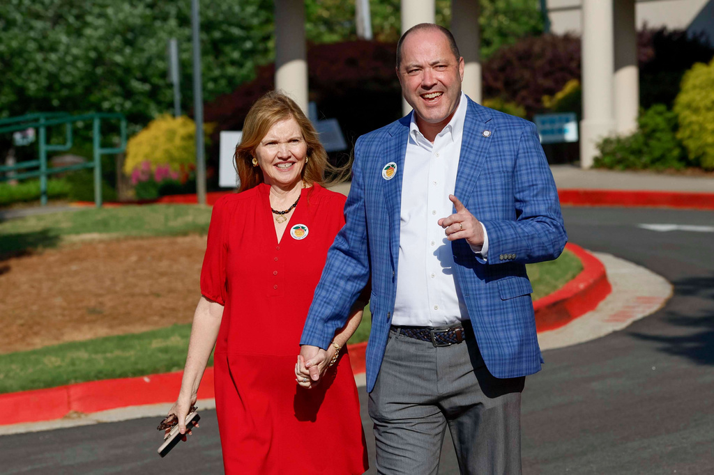 Attorney General Chris Carr walks his wife Joan Carr as he prepares to address members of the press after casting his vote during the first day of early voting for the primary elections on Monday, April 27, 2026. (Miguel Martinez/Atlanta Journal-Constitution via AP)