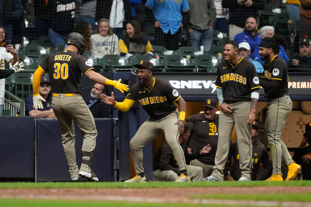 San Diego Padres' Gavin Sheets (30) is congratulated in the dugout after hitting a three-run home run during the ninth inning of a baseball game against the Milwaukee Brewers, Wednesday, May 13, 2026, in Milwaukee. (AP Photo/Aaron Gash)