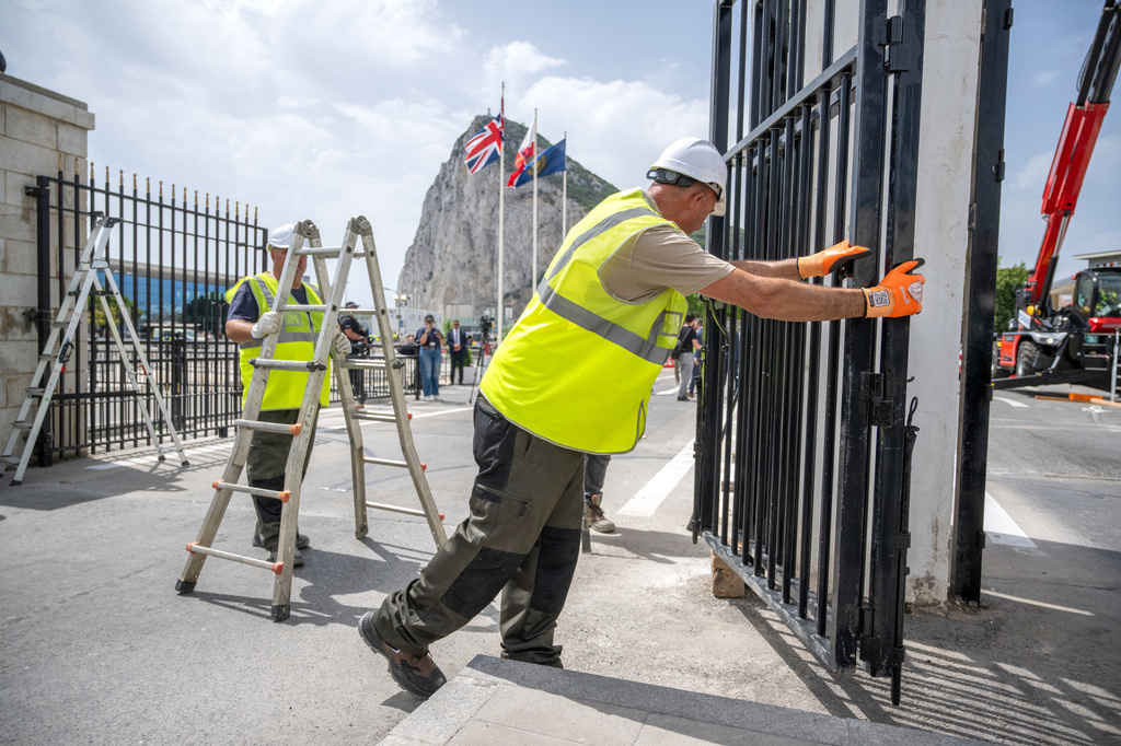 Workers remove the fence separating the disputed British overseas territory from Spain on the first day of passport-free travel under a new EU-U.K. treaty, at the border crossing between Gibraltar and Spain in La Línea de la Concepción, Spain, Wednesday, July 15, 2026. (AP Photo/Marcos Moreno)