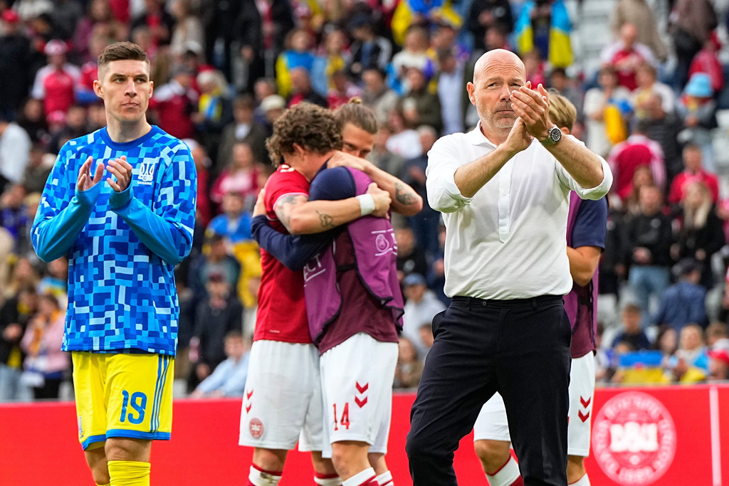 Denmark's national coach Brian Riemer, right, and players of his and Ukraine's team walk on the pitch after the international friendly soccer match between Denmark and Ukraine was cancelled in Odense, Denmark, Sunday, June 7, 2026, after Christian Eriksen has collapsed on the field again while playing for Denmark’s national team. (Bo Amstrup/Ritzau Scanpix via AP)