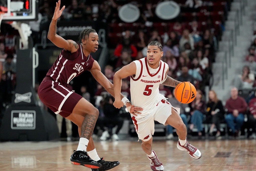 Arkansas guard Darius Acuff Jr. (5) dribbles past Mississippi State forward Jamarion Davis-Fleming (0) during the second half of an NCAA college basketball game, Saturday, Feb. 7, 2026, in Starkville, Miss. (AP Photo/Rogelio V. Solis)