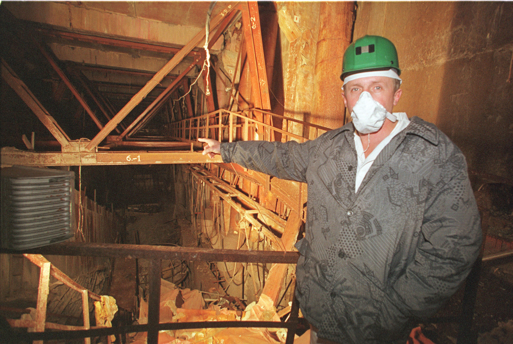 FILE - An investigator points toward damaged Reactor No. 4 inside the Chernobyl nuclear power plant in Chernobyl, Ukraine, Nov. 10, 2000. (AP Photo/Efrem Lukatsky, File)