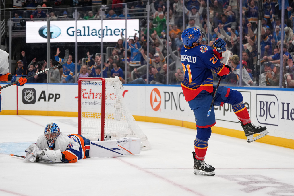 St. Louis Blues' Jimmy Snuggerud (21) celebrates after scoring past New York Islanders goaltender Ilya Sorokin, left, during the second period of an NHL hockey game Tuesday, March 10, 2026, in St. Louis. (AP Photo/Jeff Roberson)