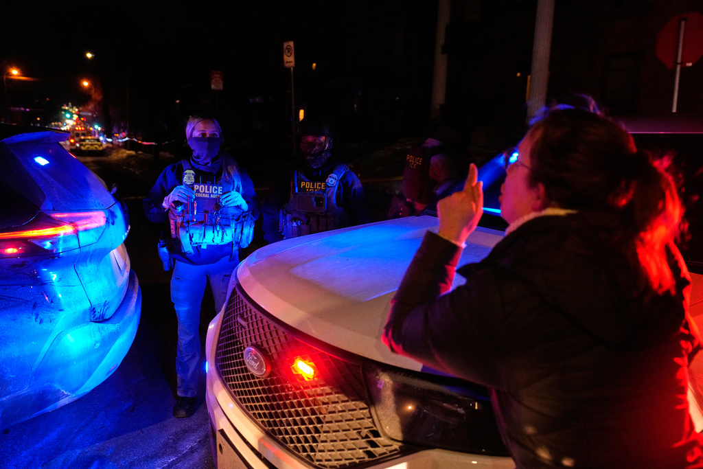A woman confronts a federal immigration officer at the scene of a reported shooting Wednesday, Jan. 14, 2026, in Minneapolis. (AP Photo/John Locher)