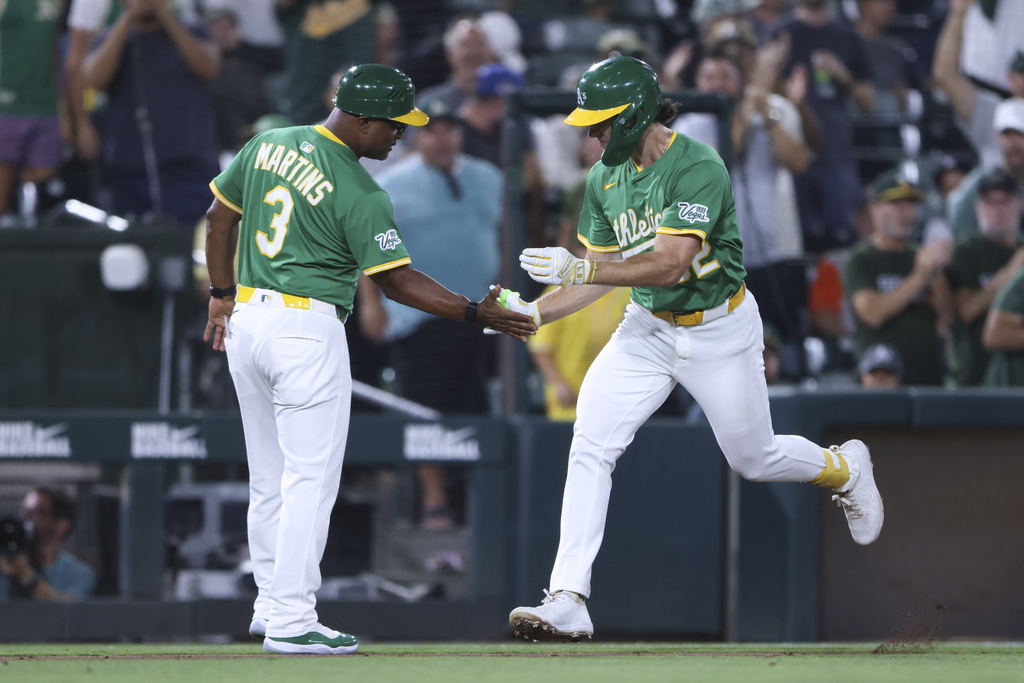 Athletics' Colby Thomas, right, and third base coach Eric Martins (3) celebrate Thomas's solo home run during the seventh inning of a baseball game against the Detroit Tigers, Monday, Aug. 25, 2025, in West Sacramento, Calif. (AP Photo/Scott Marshall)