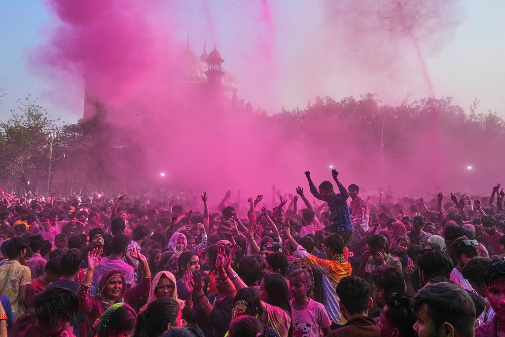 Revelers dance under colored water and powder sprayed from above at the Shri Krishna Janmabhoomi Temple complex during Holi festival celebrations in Mathura, India, on Feb. 27, 2026. (AP Photo/Manish Swarup)